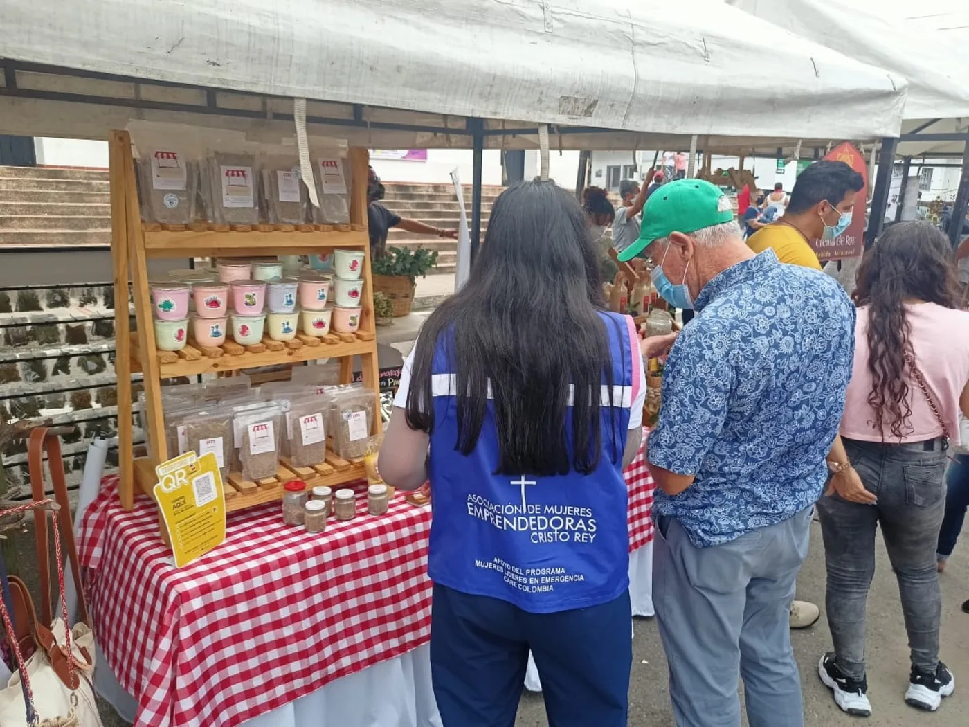 Mujer de la Asociación de Mujeres Emprendedoras del Cristo Rey atendiendo el stand de El Tarantin en una feria