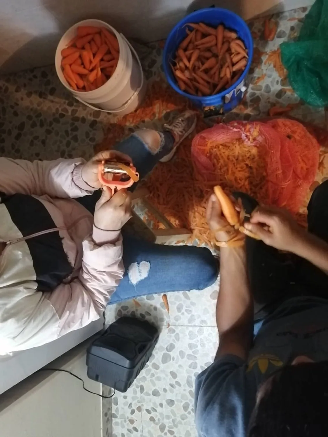 Manos de mujeres pelando zanahoria fresca en la producción artesanal de El Tarantin