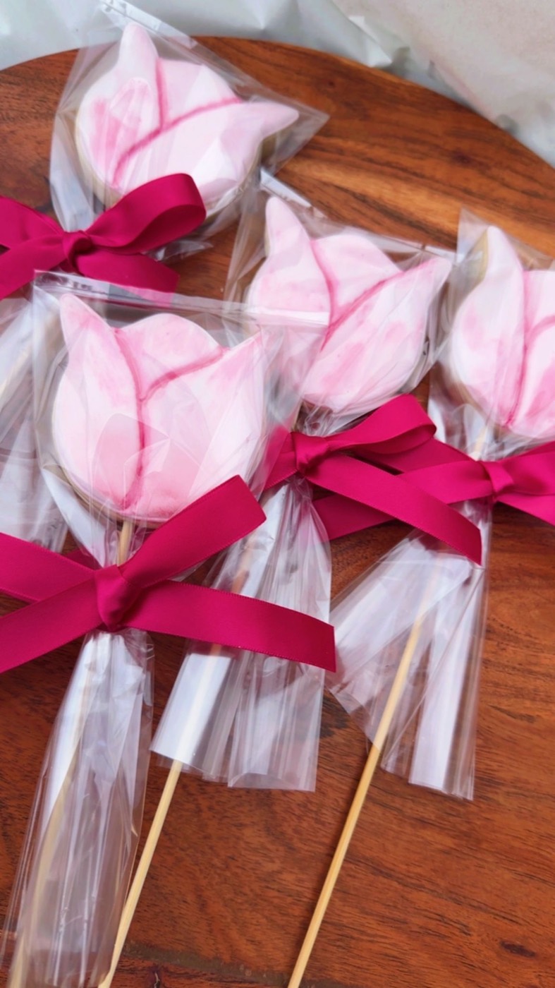 Galletas tulipán rosadas en palito con lazo fucsia